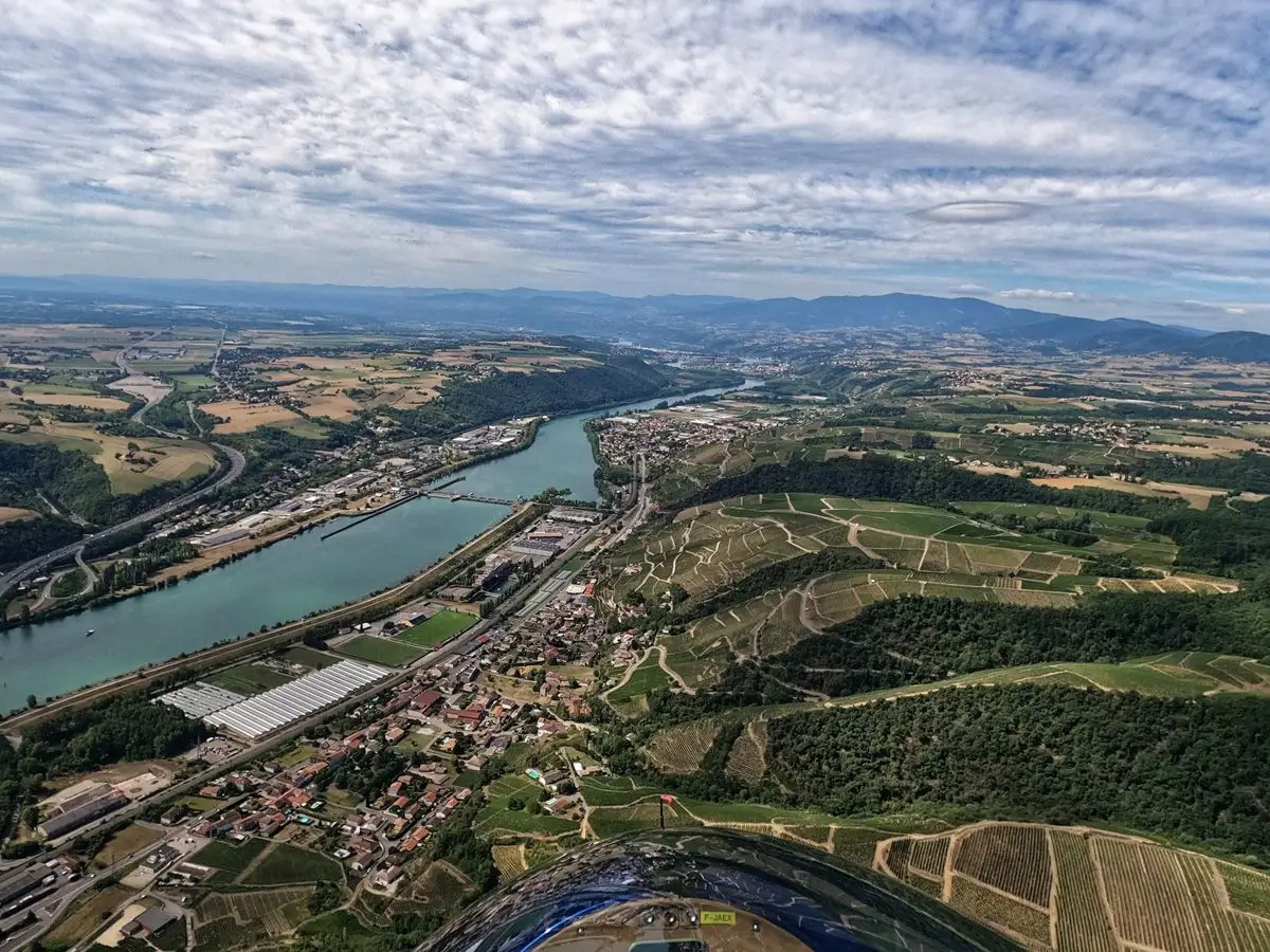 Vue aérienne d'un fleuve bordé de villages, de vignes et de collines boisées